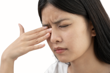 目のゴロゴロ感や涙目に悩む人が鏡で目元を確認している様子のイメージ